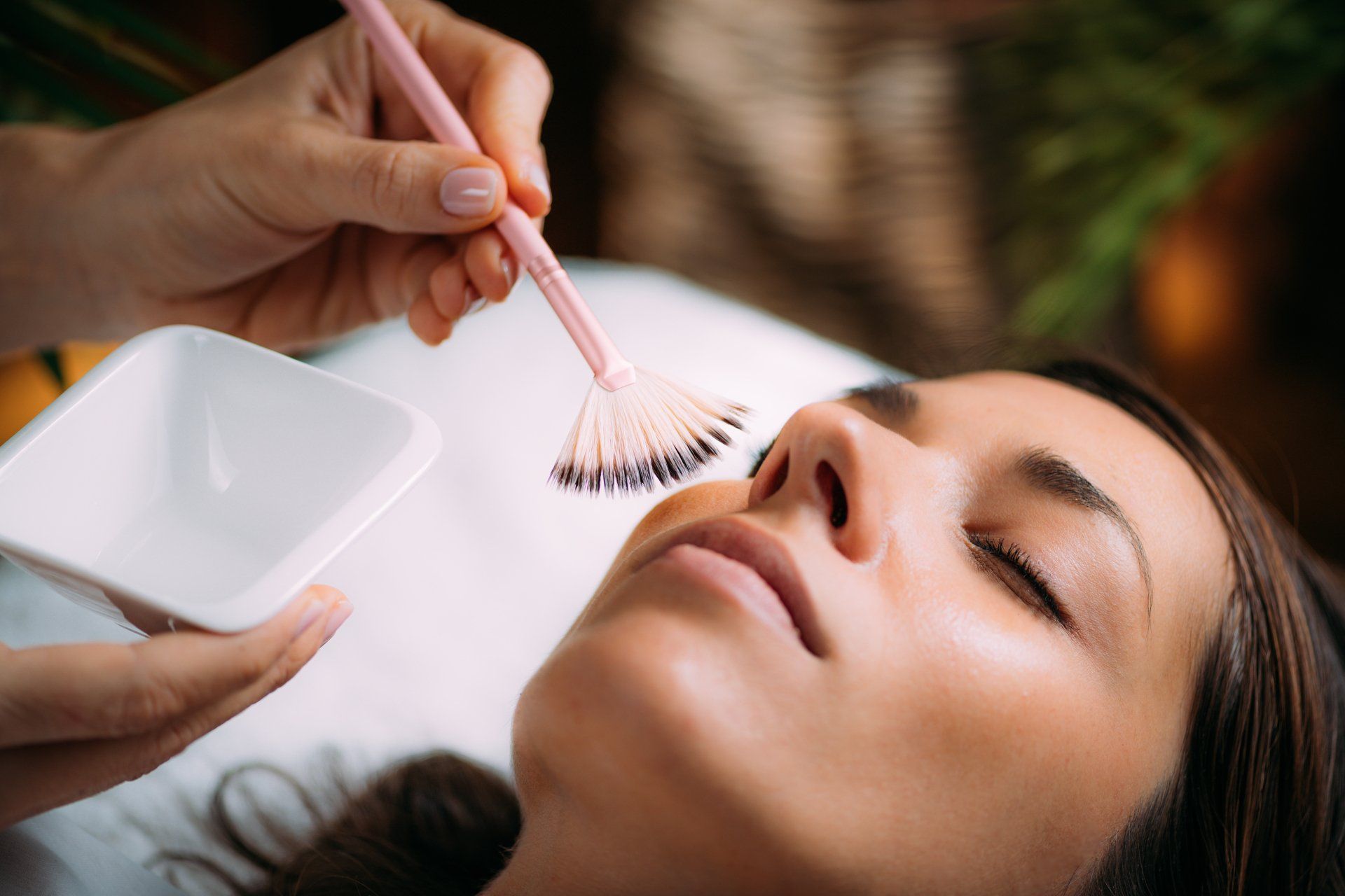 A woman is getting a facial treatment at a spa.