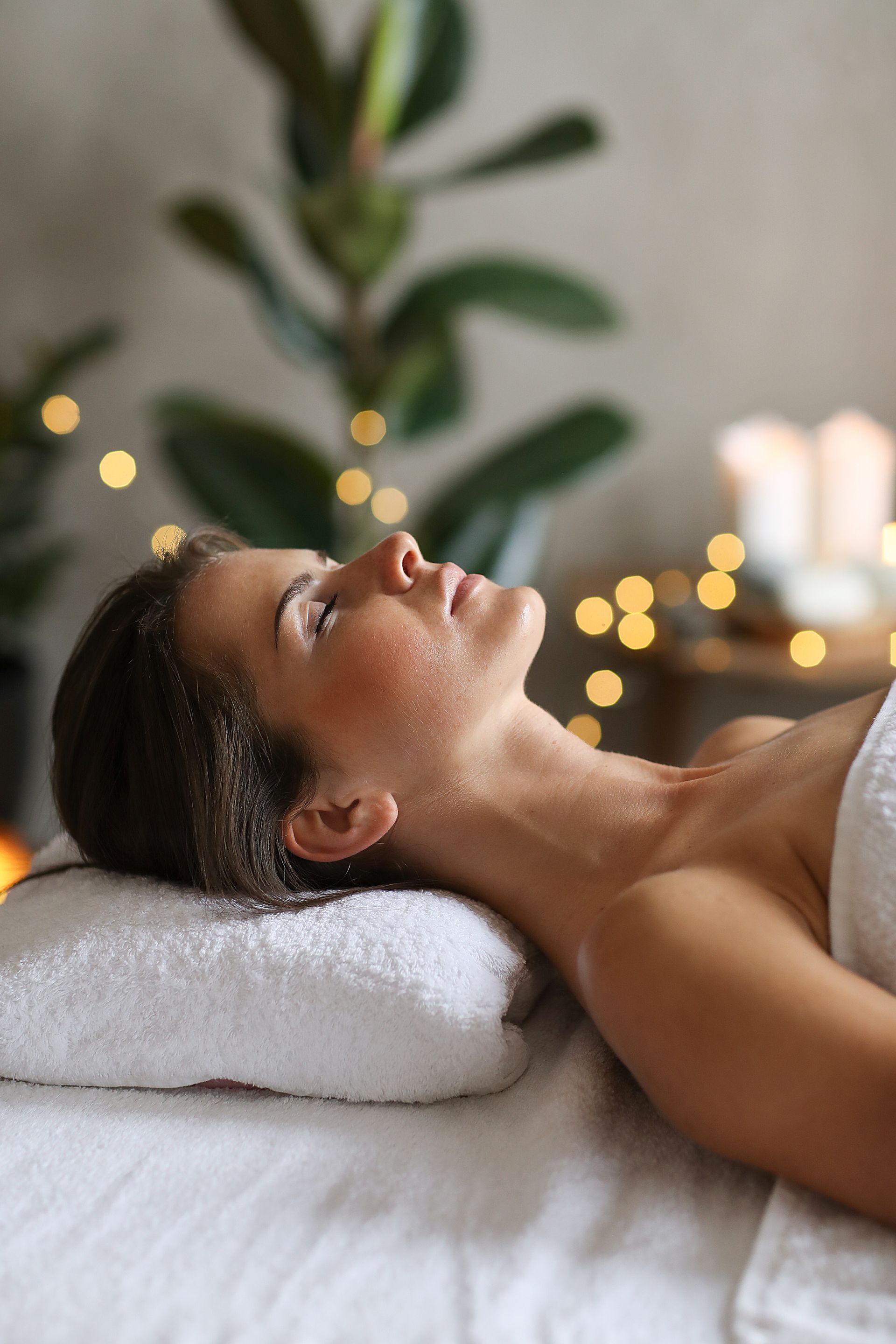 A woman is laying on a massage table in a spa.