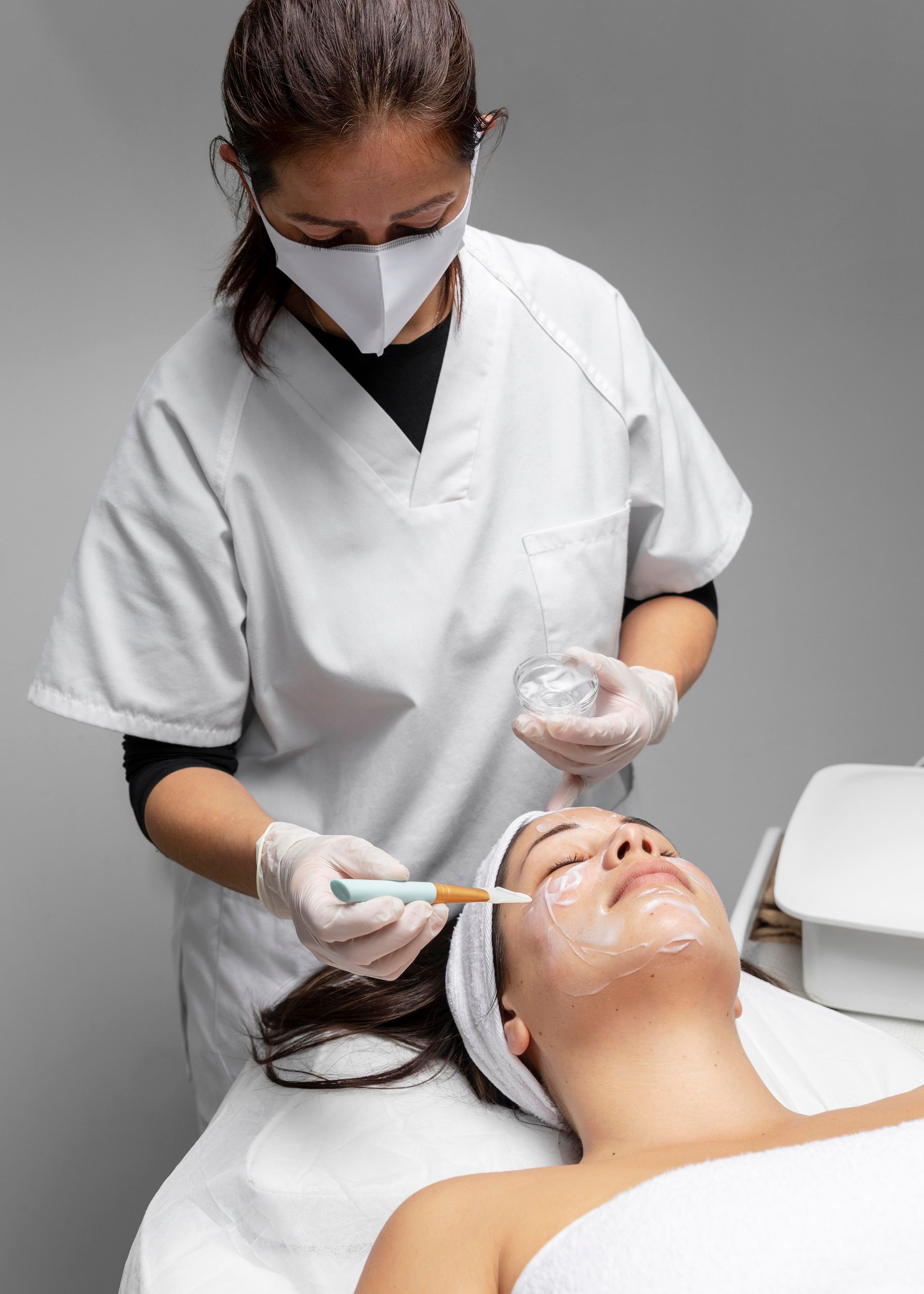 A woman is getting a facial treatment at a beauty salon.