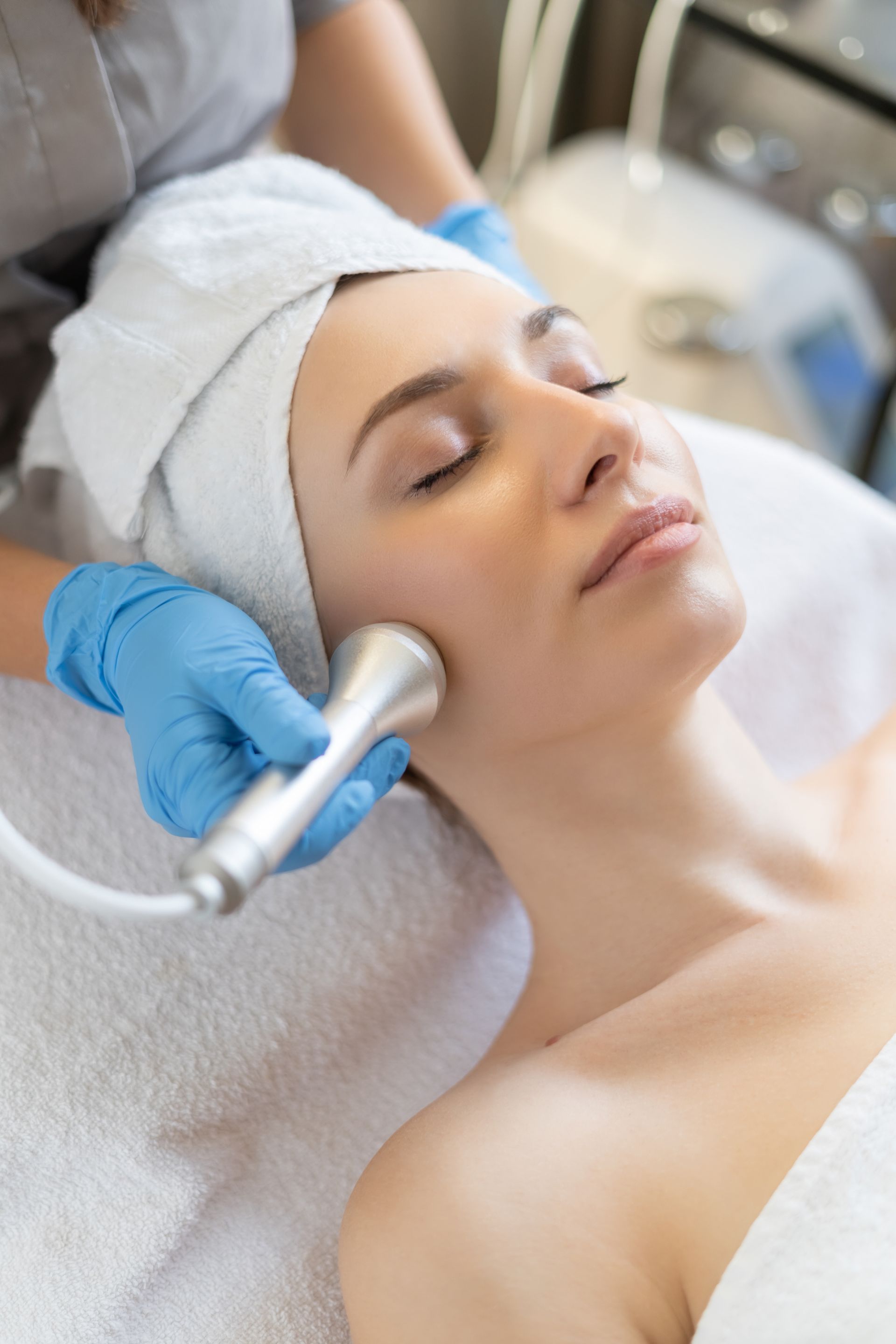 A woman is getting a facial treatment at a beauty salon.