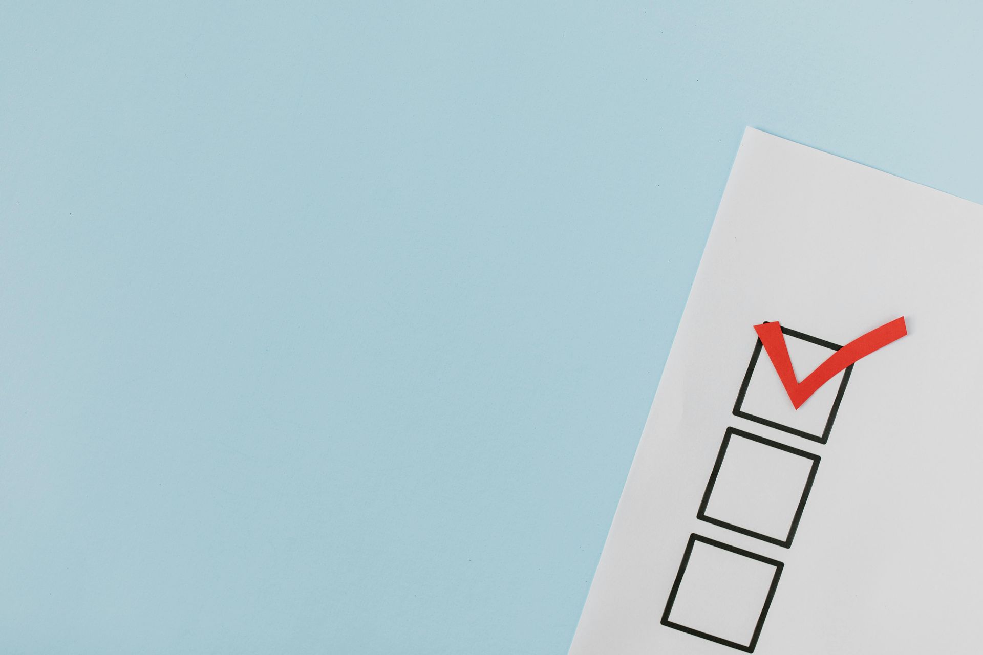 A checklist with a red check mark on a blue background.