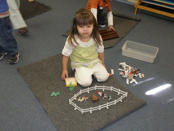 Little Girl Playing Toy Animals — Riverside, CA — Cottonwood Montessori