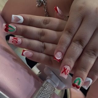 A close-up of square-shaped manicured nails featuring cherry, heart, and 