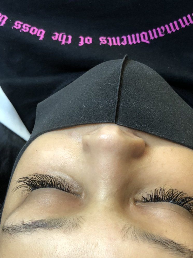 Close-up of a person wearing a black face mask, showcasing long, dark eyelash extensions.