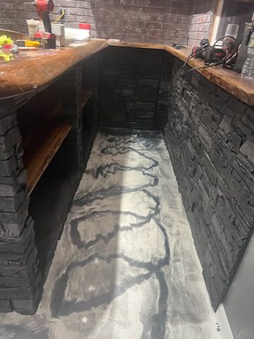 A narrow room with a brick wall and a concrete floor.