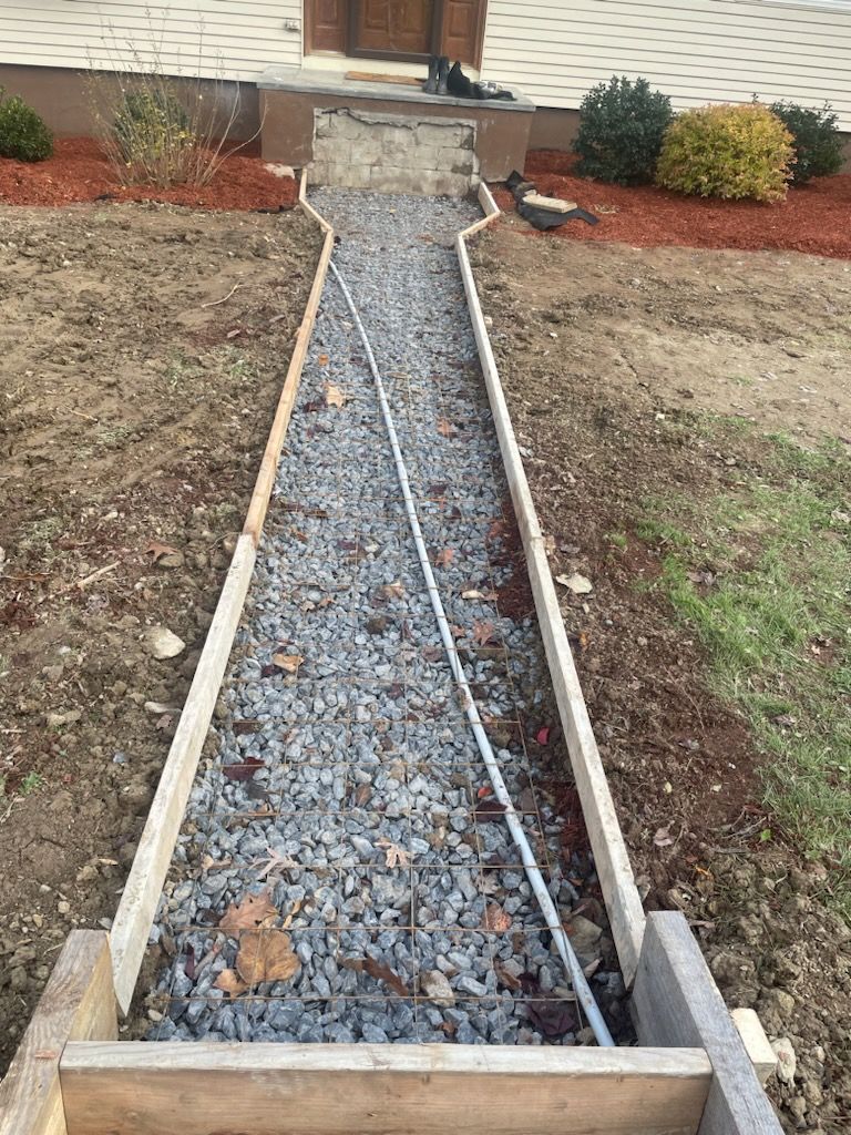 A concrete walkway is being built in front of a house.