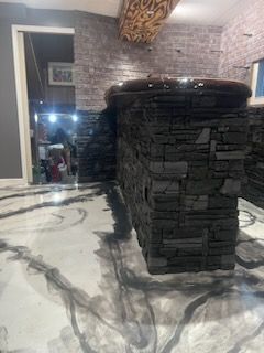 A room with a brick wall and a concrete floor.