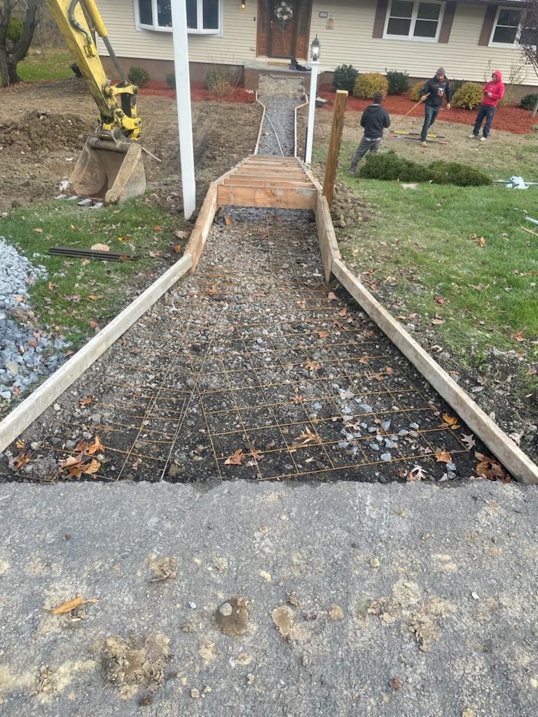 A concrete walkway is being built in front of a house.