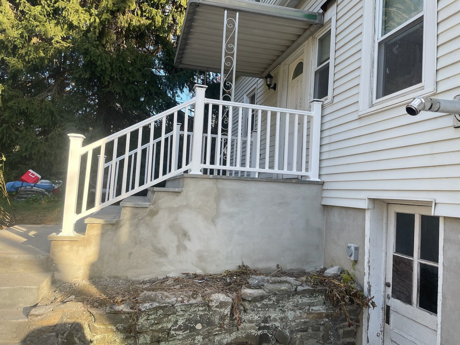A white house with a white railing and stairs