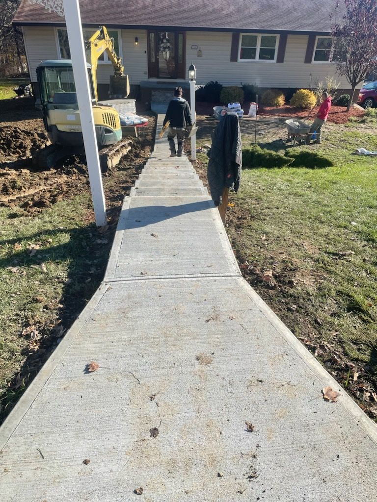 A concrete walkway is being built in front of a house.