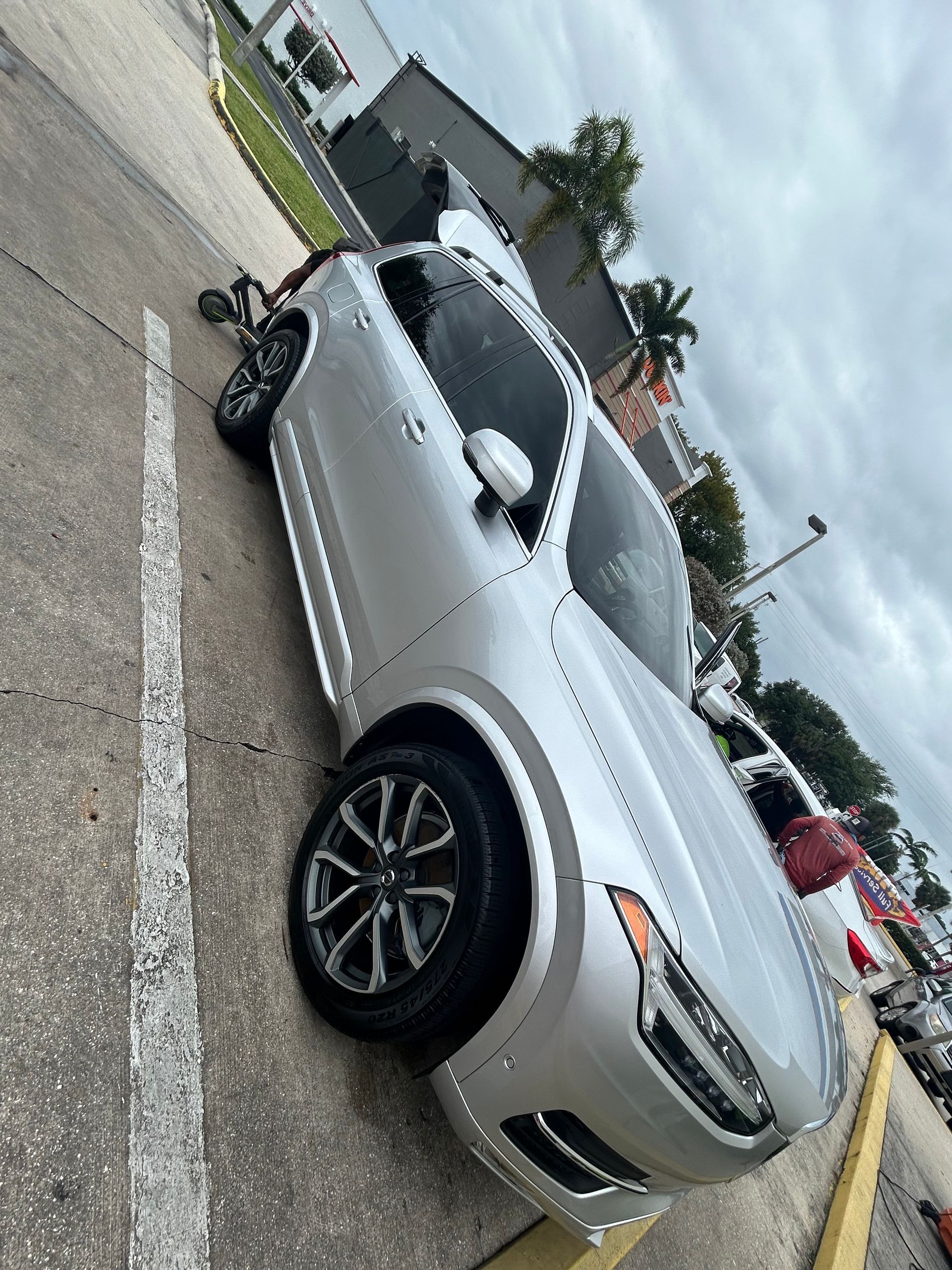 Silver SUV parked diagonally on asphalt, cloudy day.
