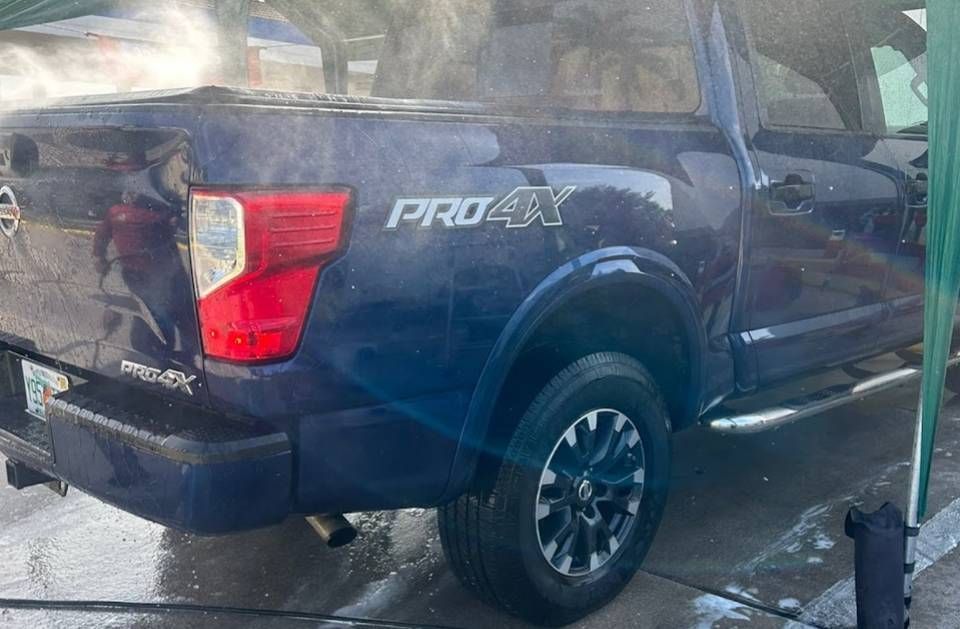 Blue Nissan Titan Pro4X truck being washed at a car wash.