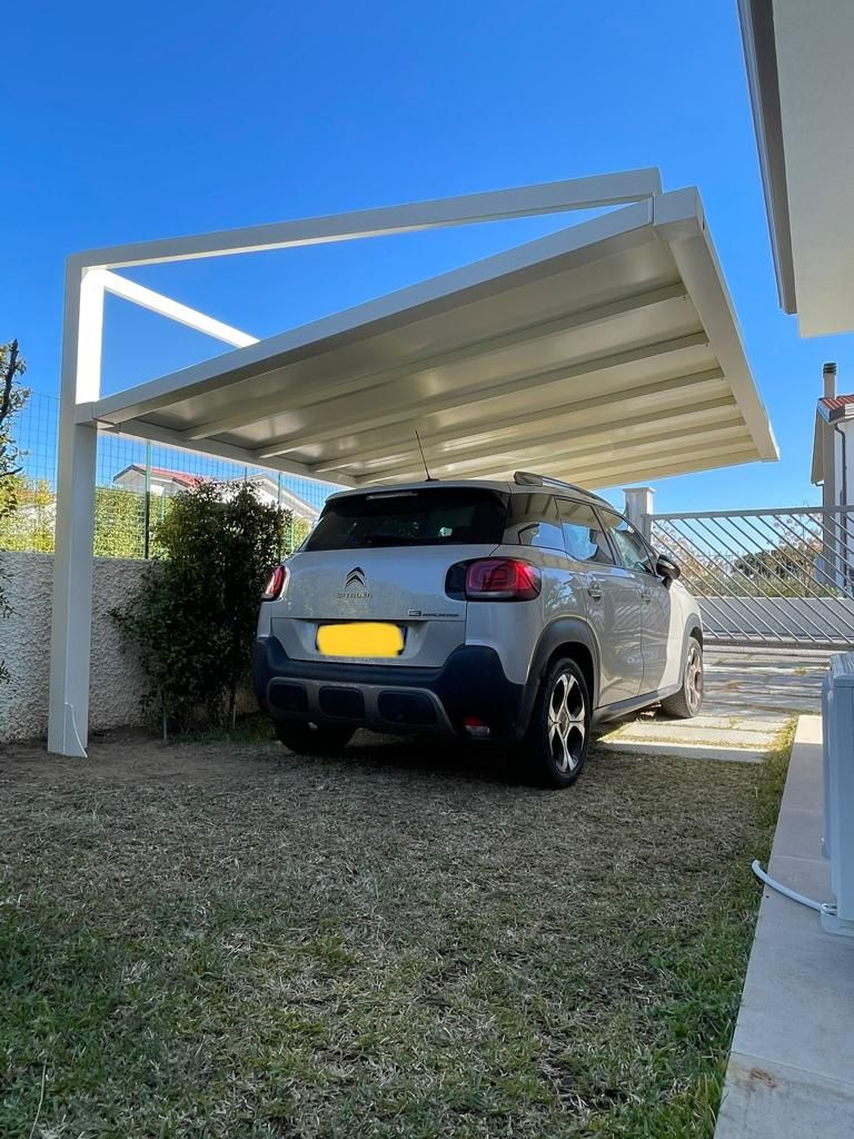 Progettazione e installazione di pergola carport per un'auto realizzata con struttura in acciaio bianca
