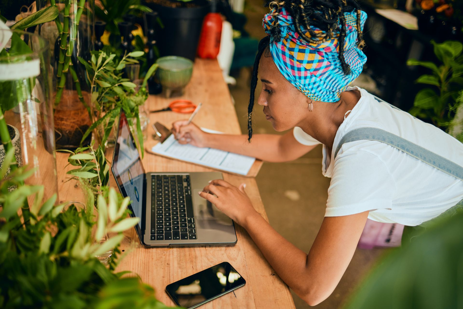 A woman is sitting at a table using a laptop computer.