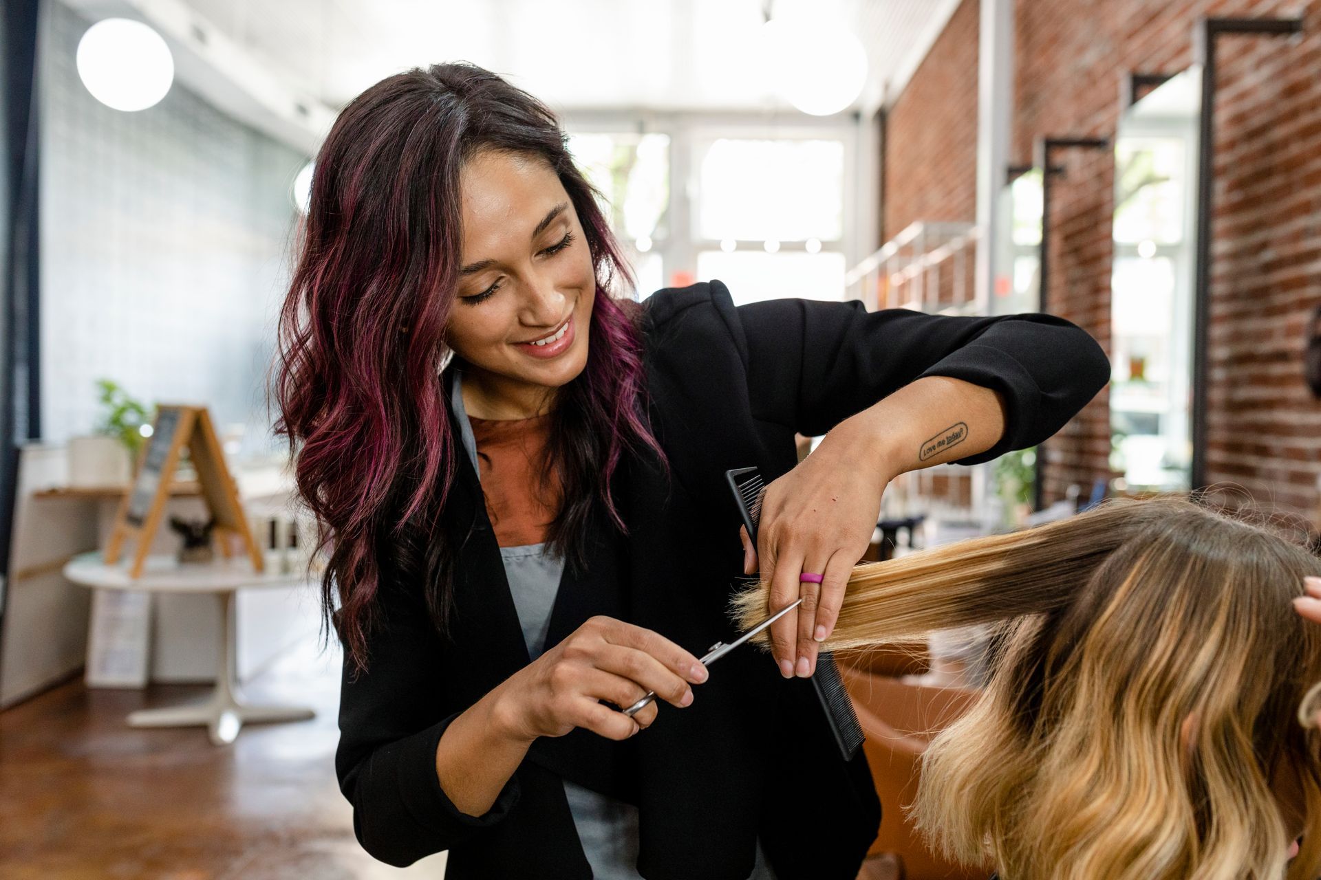 A woman is getting her hair cut by a hairdresser in a salon.