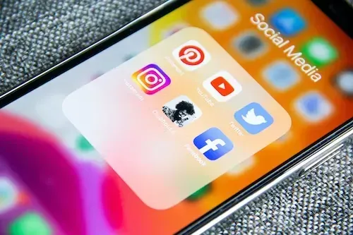 A close up of a cell phone with social media icons on it