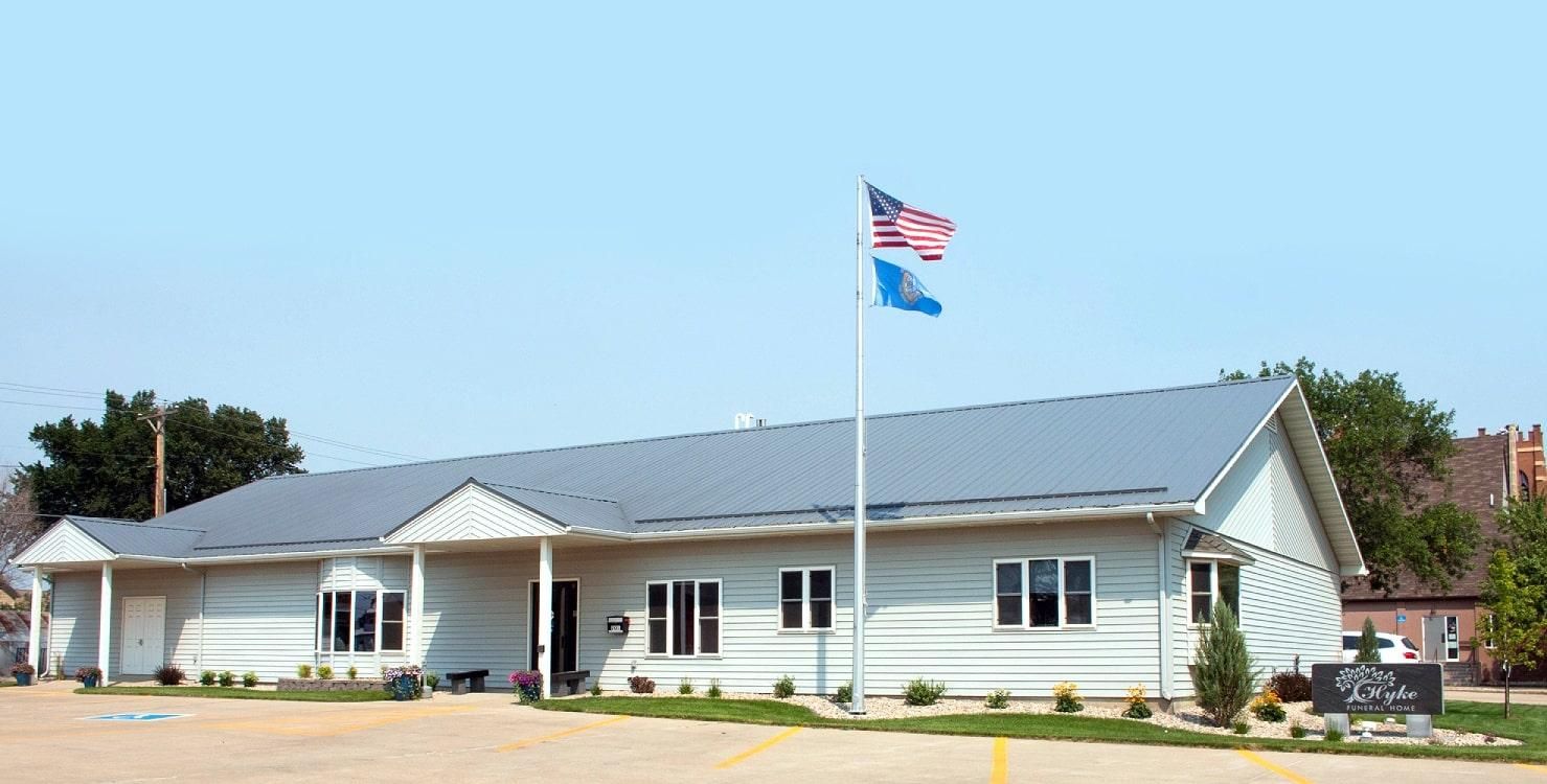The front door of a house with a porch and plants in front of it.