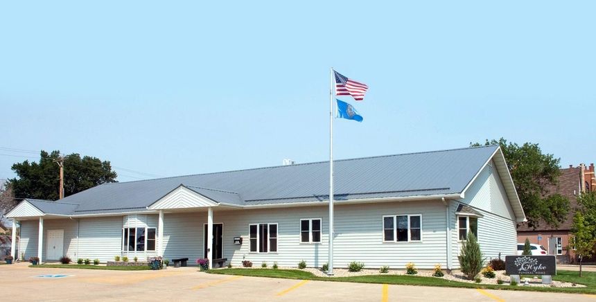 The front door of a house with a porch and plants in front of it.
