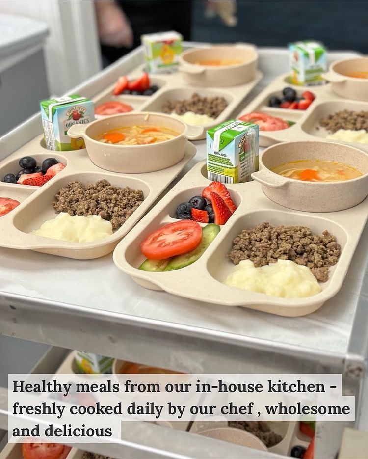 Tray of prepared meals: soup, ground meat, mashed potatoes, fruit, and juice boxes.