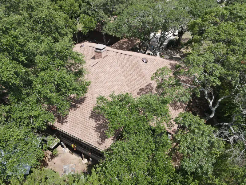 An aerial view of a house surrounded by trees.