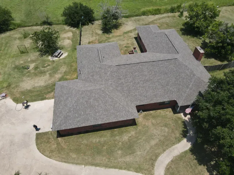 An aerial view of a house with a gray roof