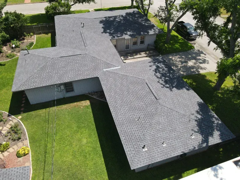 An aerial view of a house with a gray roof