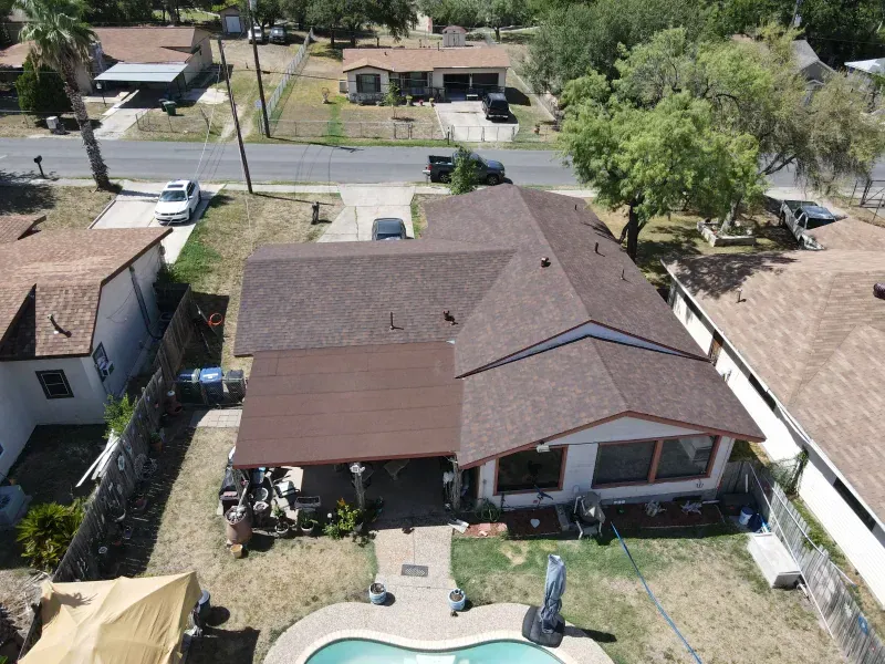 An aerial view of a house with a pool in the backyard