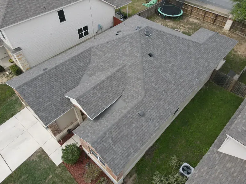 An aerial view of a house with a trampoline in the backyard.