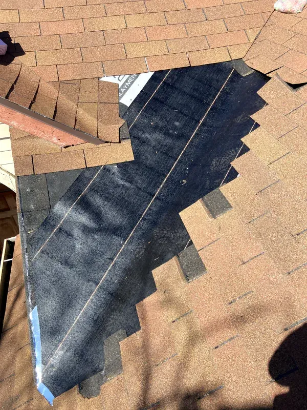 A close up of a roof with a piece of black tape on it.