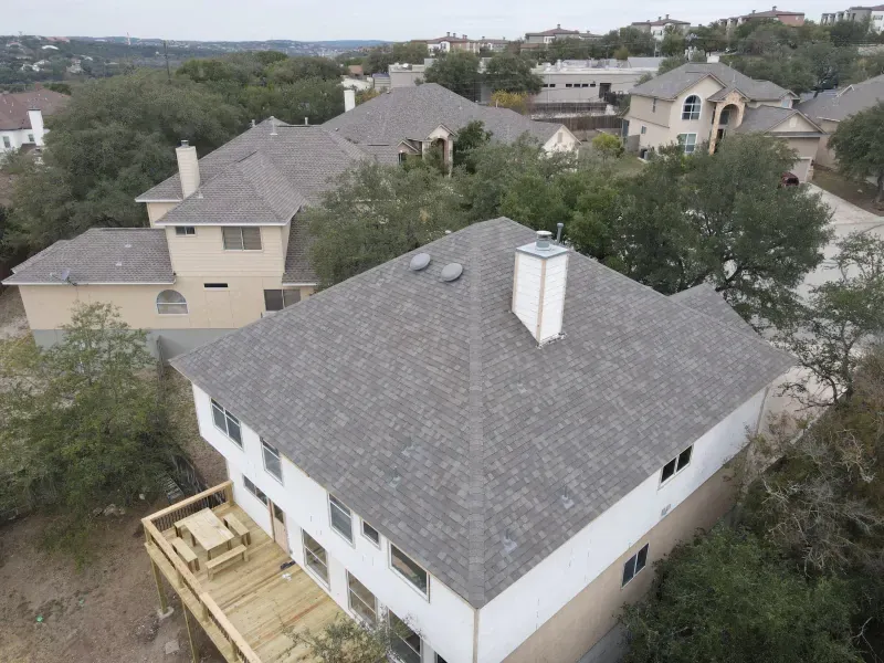An aerial view of a house with a gray roof