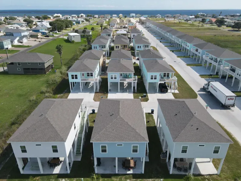 An aerial view of a row of houses with the ocean in the background