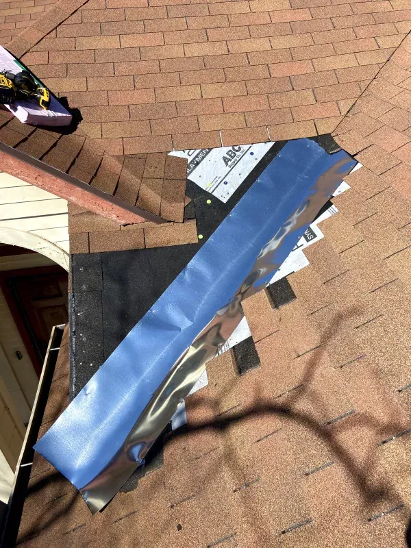 A piece of blue tape is laying on top of a brick roof.
