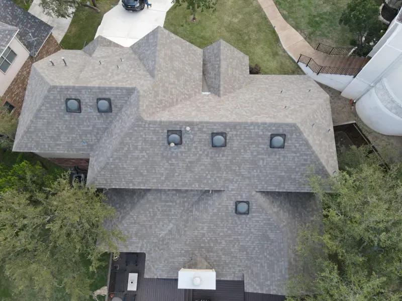 An aerial view of a house with a roof that has a lot of windows.