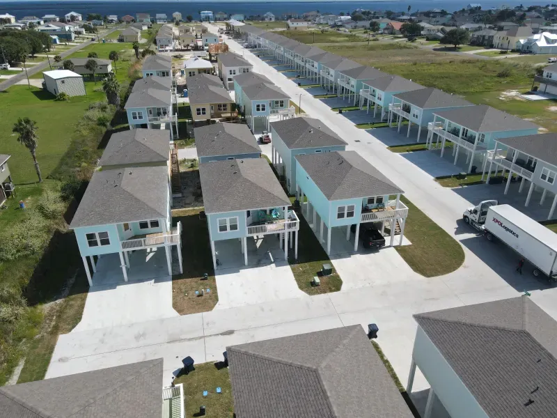 An aerial view of a residential neighborhood with a white truck parked on the side of the road