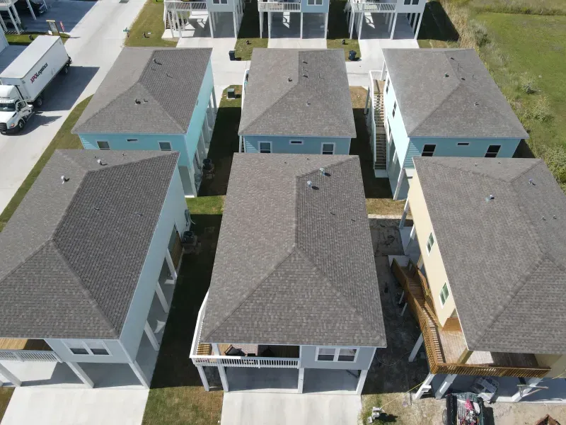 An aerial view of a row of houses with gray roofs