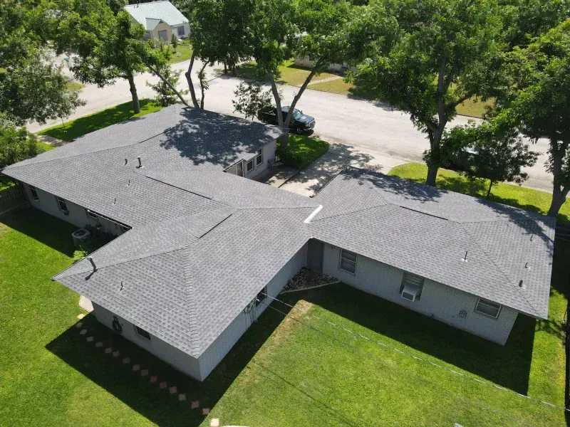 An aerial view of a house with a gray roof