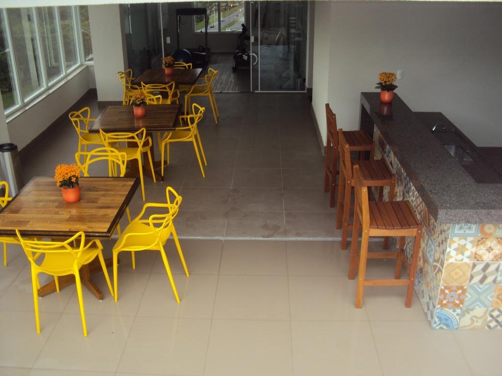 Uma sala com cadeiras e mesas amarelas e um bar