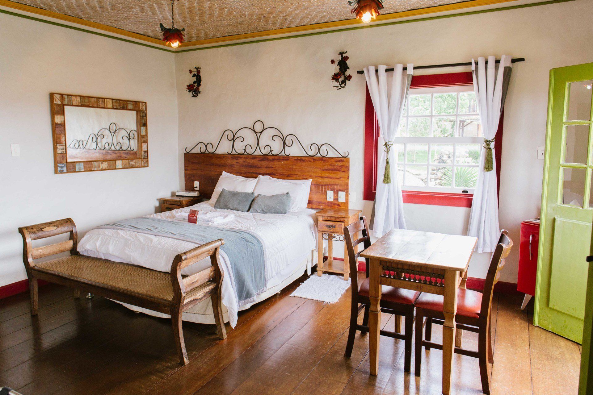 Um quarto com uma cama king size, uma mesa e cadeiras.