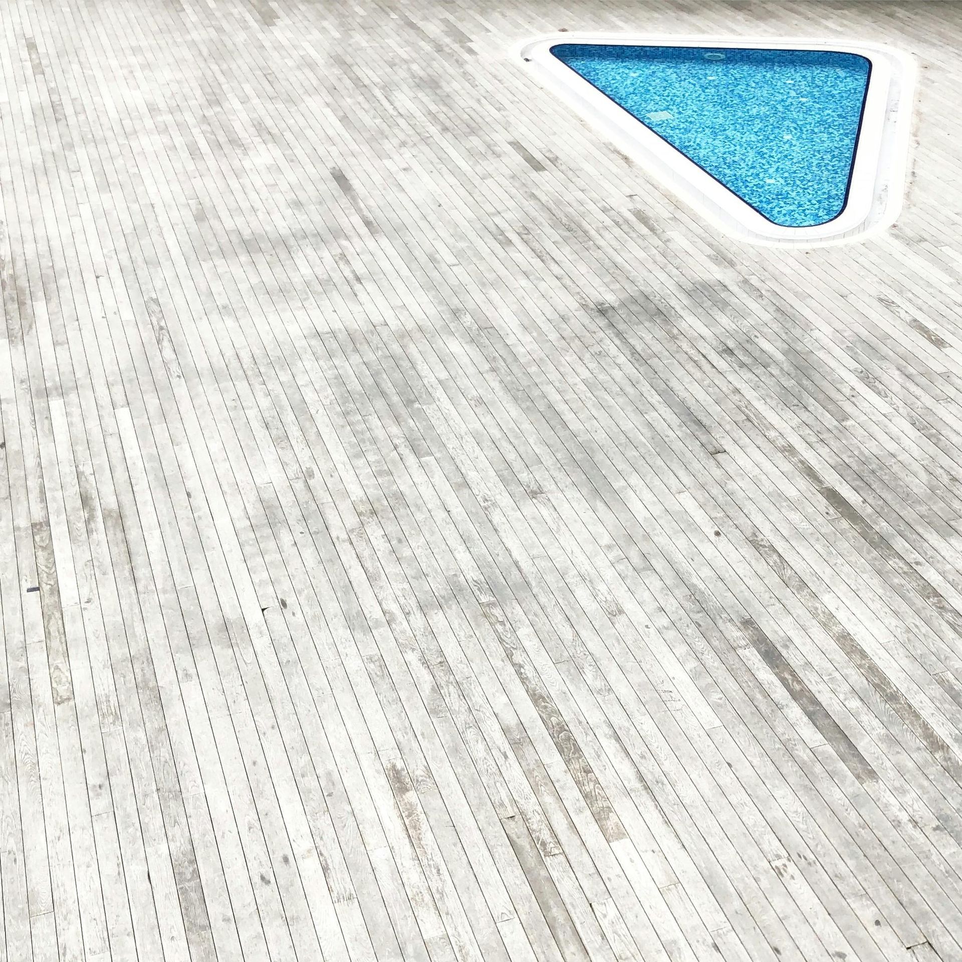 Knockdown “cool deck” texture surrounding a swimming pool edge.
