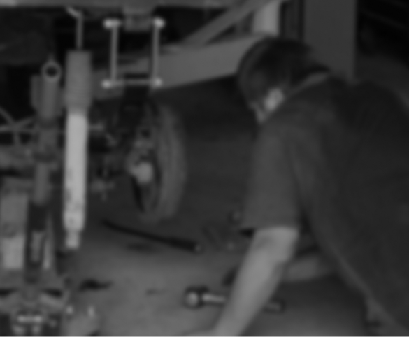A person working on the wheel assembly of a vehicle in an auto repair shop. | Performance Automotive Repair