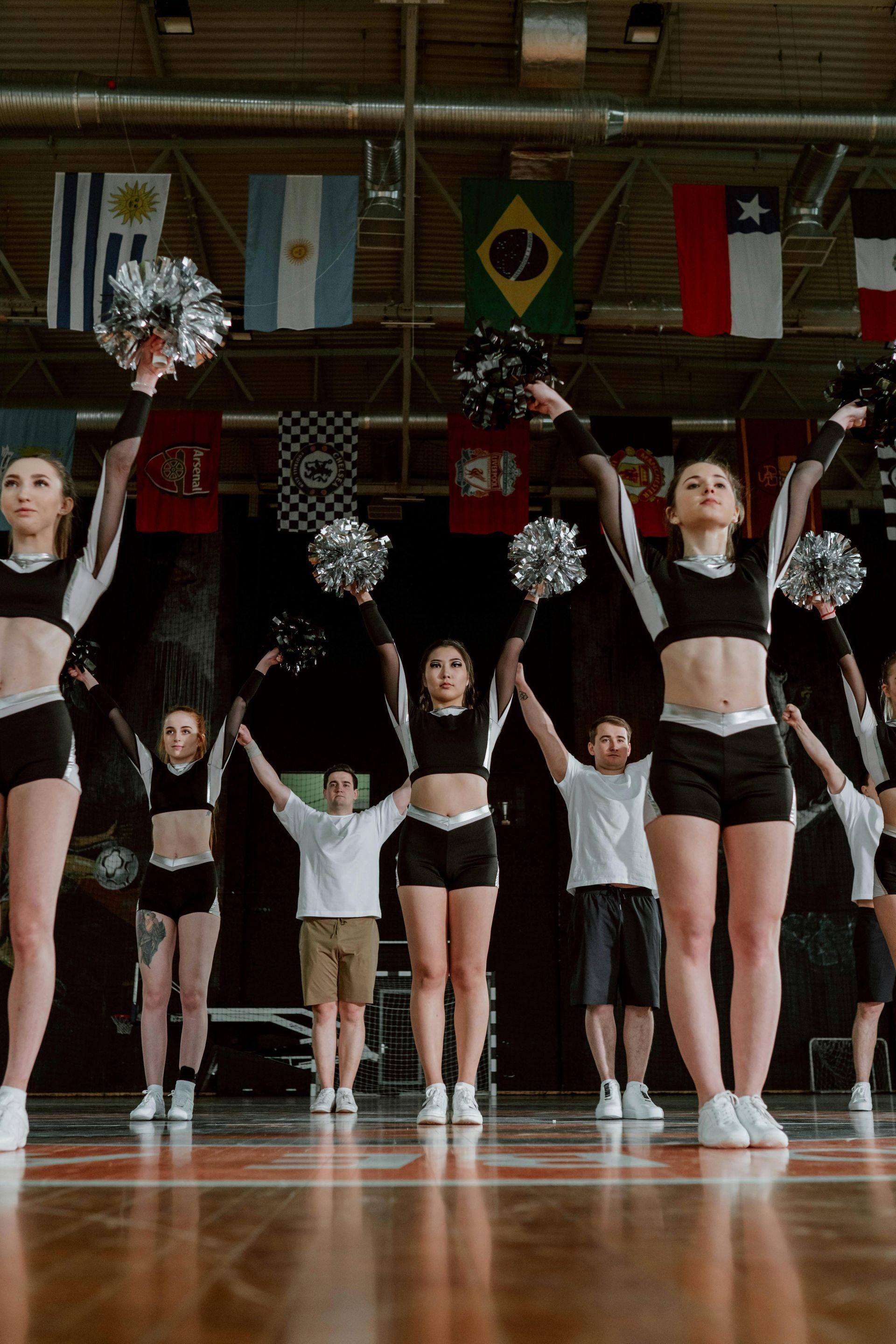 A group of cheerleaders are performing on a basketball court.