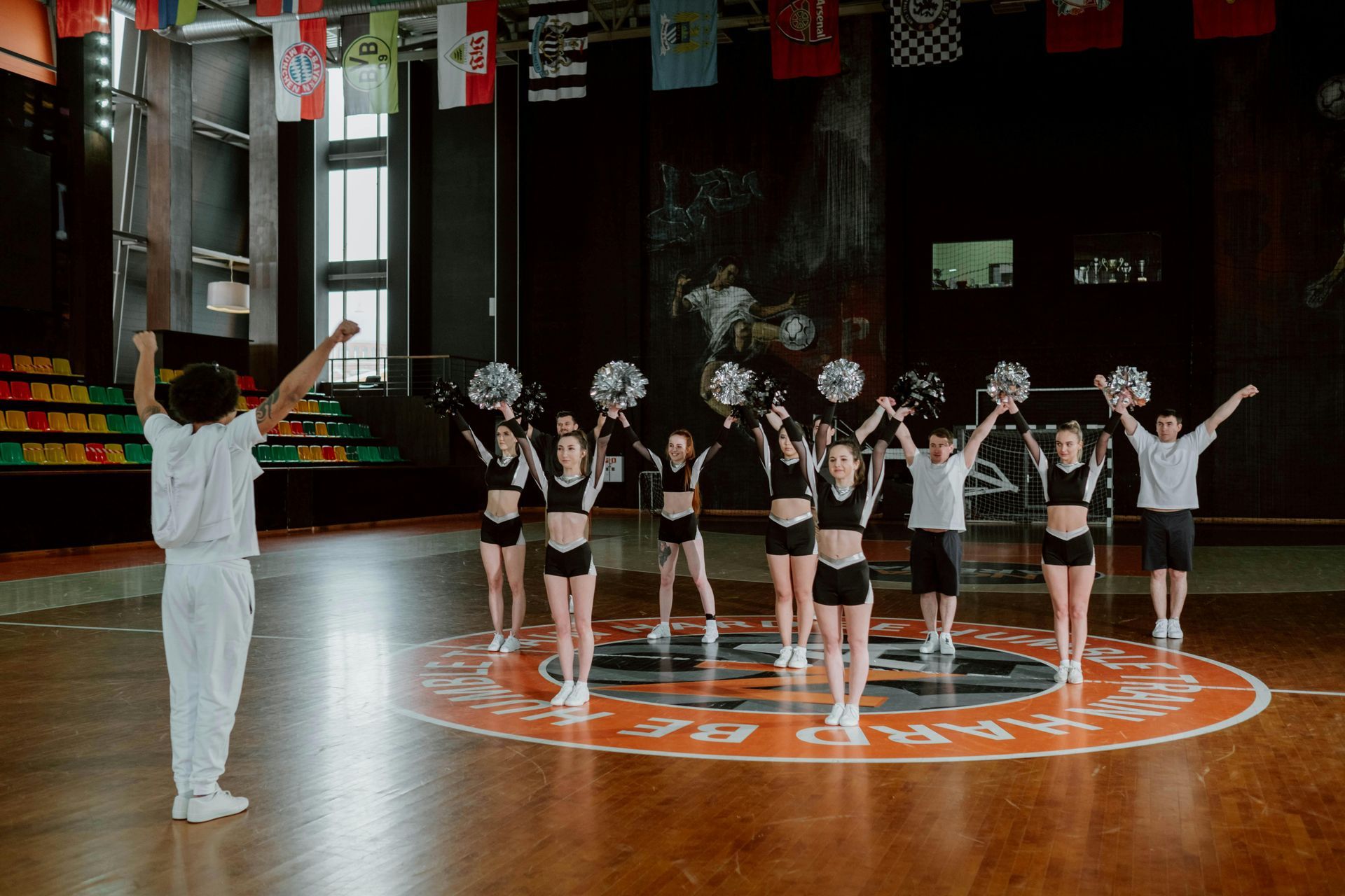 A group of cheerleaders are performing on a basketball court.