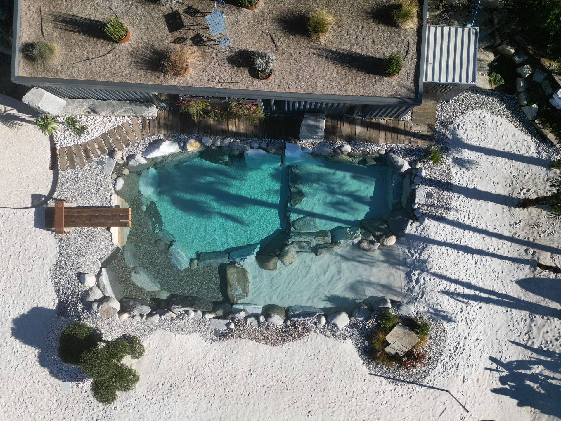 piscina naturale modello Caraibi con sabbia e rocce di Rocks Design