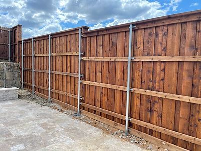 A sliding gate is open to a driveway leading to a house.