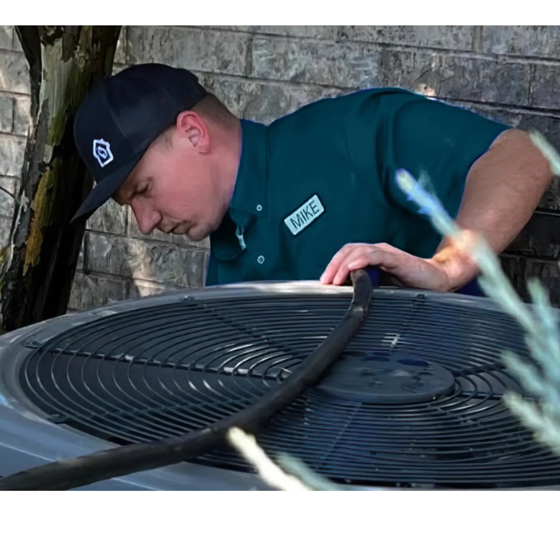  Finnegan’s Heating Air Conditioning - A man wearing a hat and a shirt that says ' maintenance ' on it is working on an air conditioner