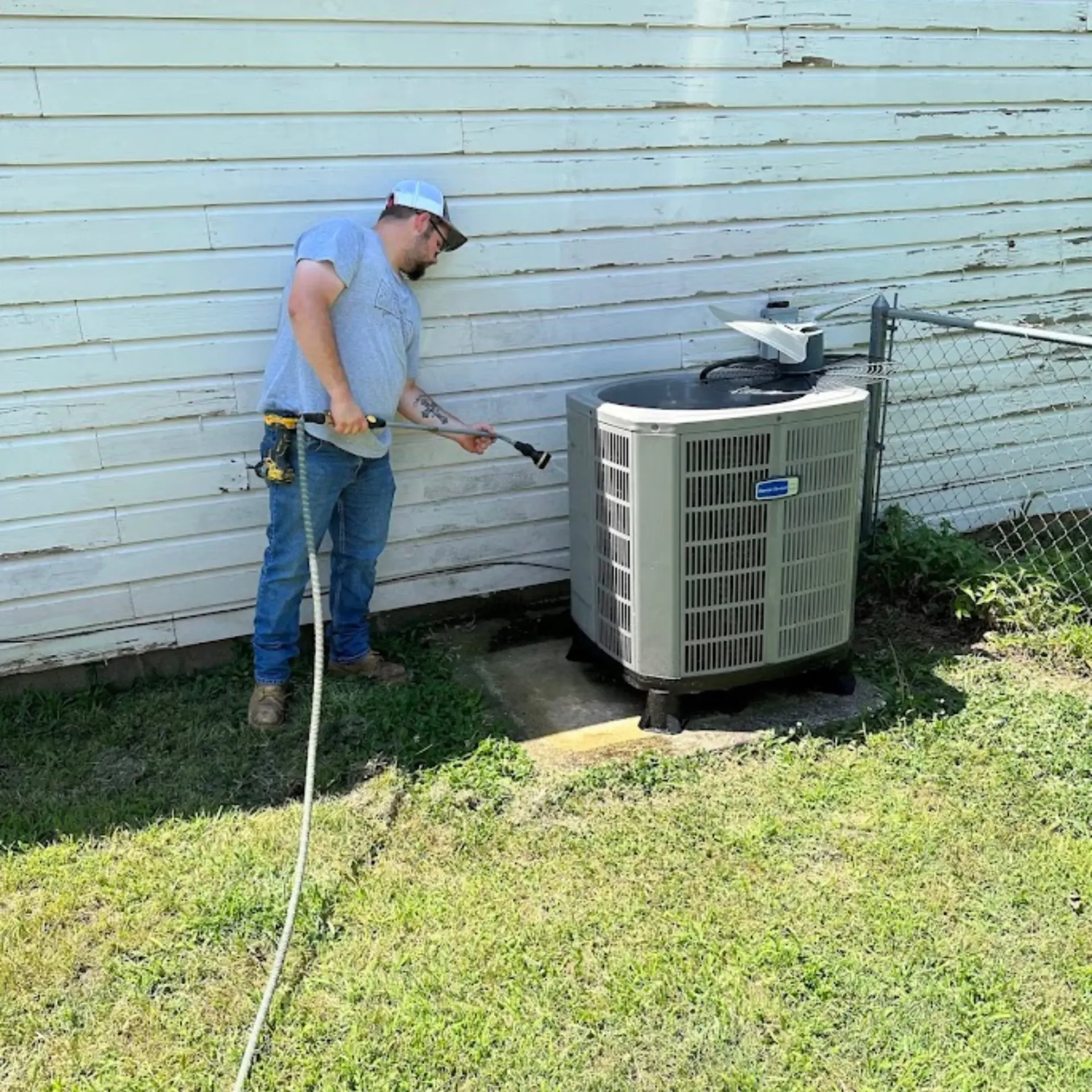 Finnegan’s Heating Air Conditioning - A man in a blue shirt is working on a boiler