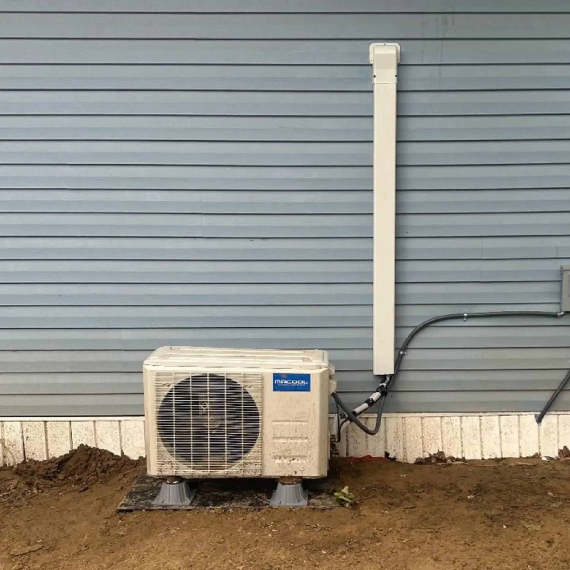 Finnegan’s Heating Air Conditioning - An air conditioner is mounted to the side of a house