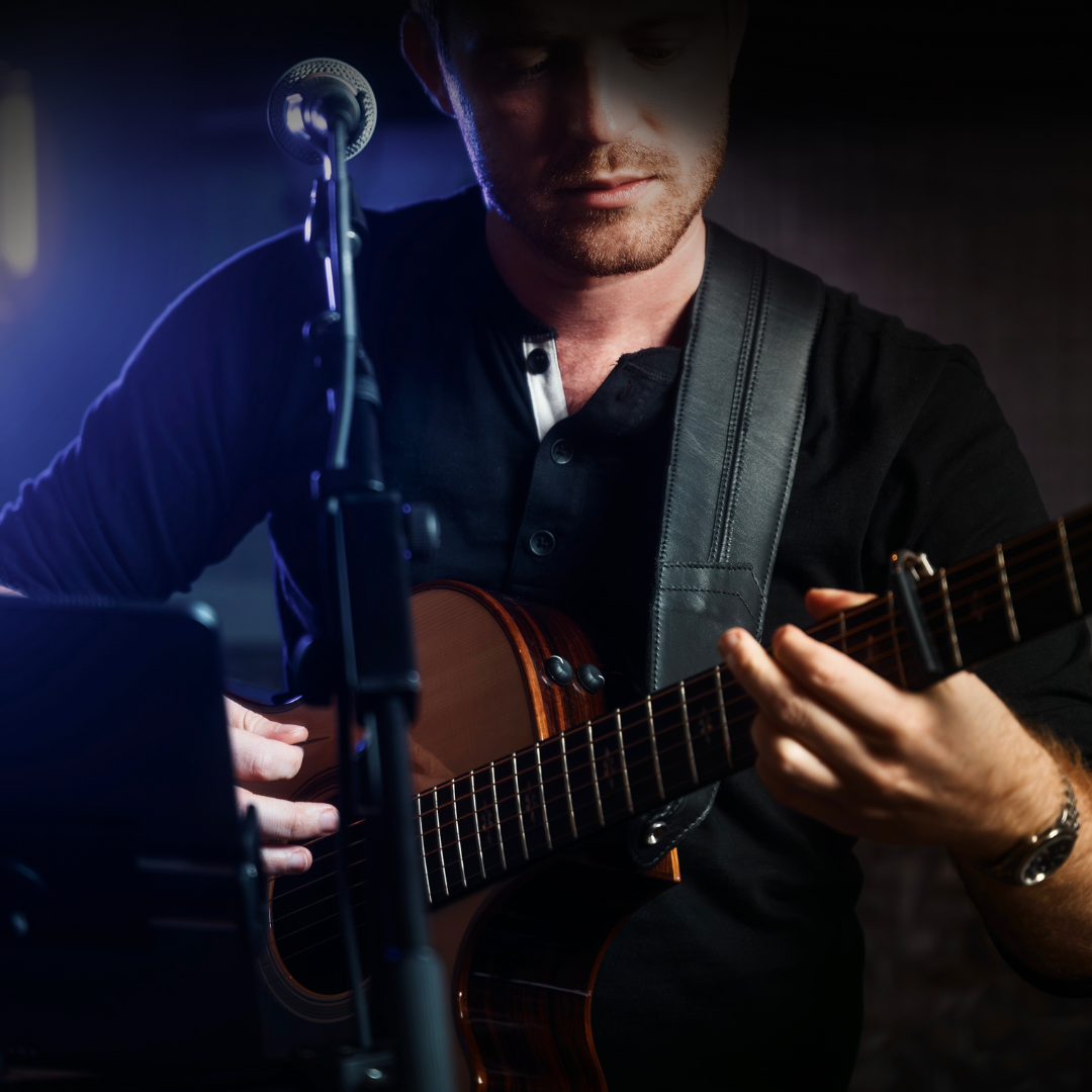 People at tables and bar in a busy modern bar, watching TVs. Metal decor, dim lighting.