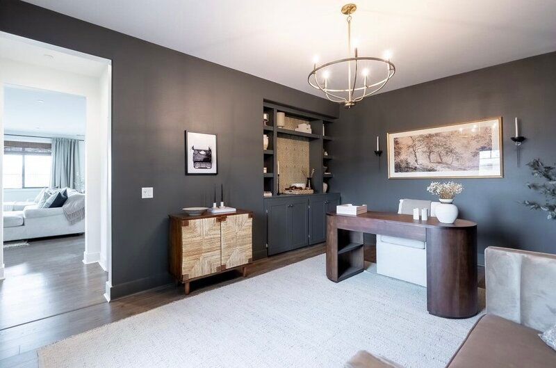 Home office with gray walls, dark wood desk, and white rug.