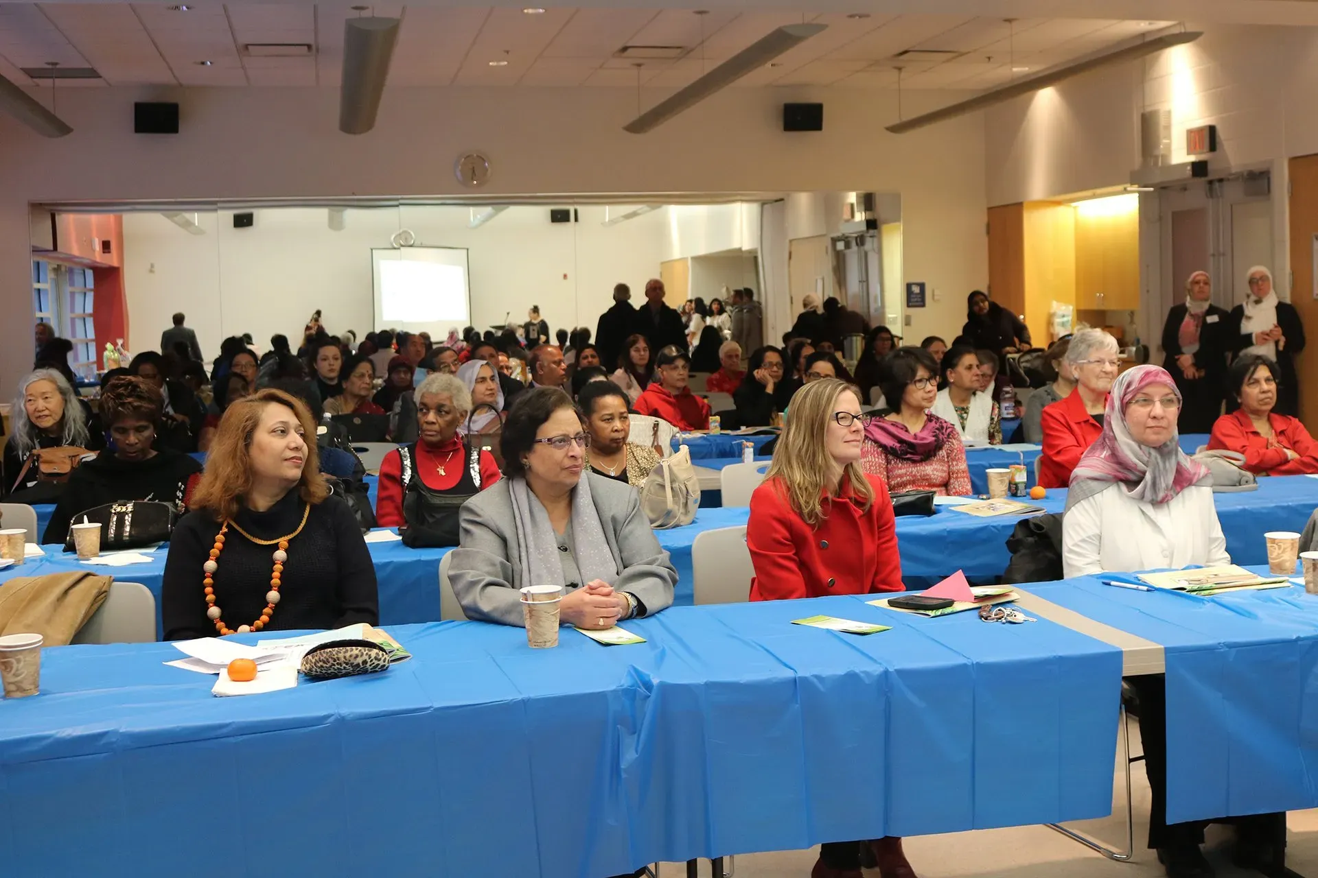 A large group of people are sitting at tables in a room.